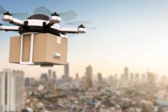 A delivery drone hovering over a modern cityscape